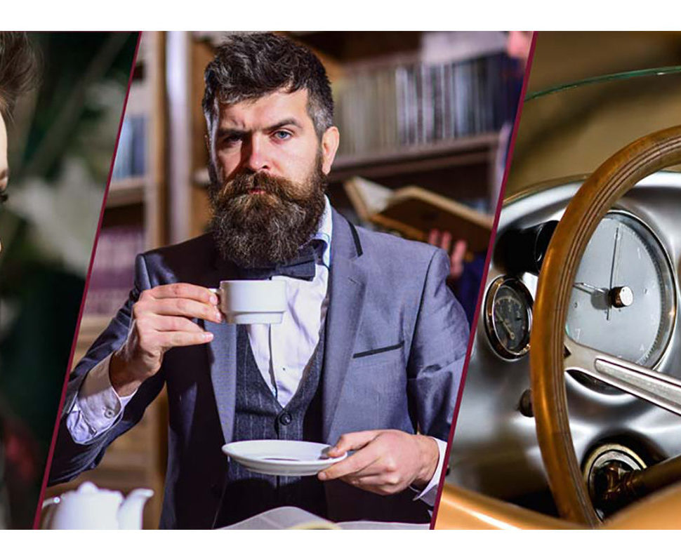 Ein bärtiger Mann im Anzug sitzt in einer Bibliothek und hält eine Teetasse mit Untertasse. Neben ihm ist ein Teil des Armaturenbretts und des Lenkrads eines Oldtimers zu sehen. | adelstitel-kaufen.com